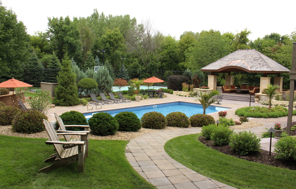 Mid-sized traditional backyard rectangular pool in Minneapolis with concrete pavers.
