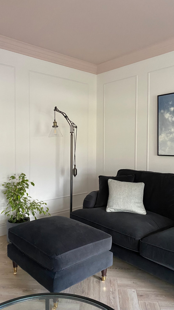This is an example of a large scandi formal and grey and pink enclosed living room feature wall in Other with white walls, laminate floors, a wood burning stove, a plastered fireplace surround, a corner tv, beige floors, all types of ceiling and panelled walls.