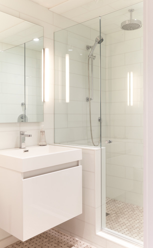 This is an example of a small contemporary 3/4 bathroom in Toronto with a console sink, flat-panel cabinets, white cabinets, an alcove shower, white tile, mosaic tile floors, ceramic tile, white walls, quartzite benchtops, brown floor and a hinged shower door.