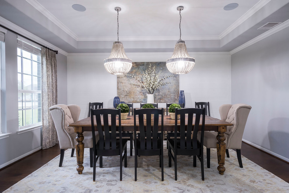 This is an example of a separate dining room in Houston with grey walls, dark hardwood floors and brown floor.