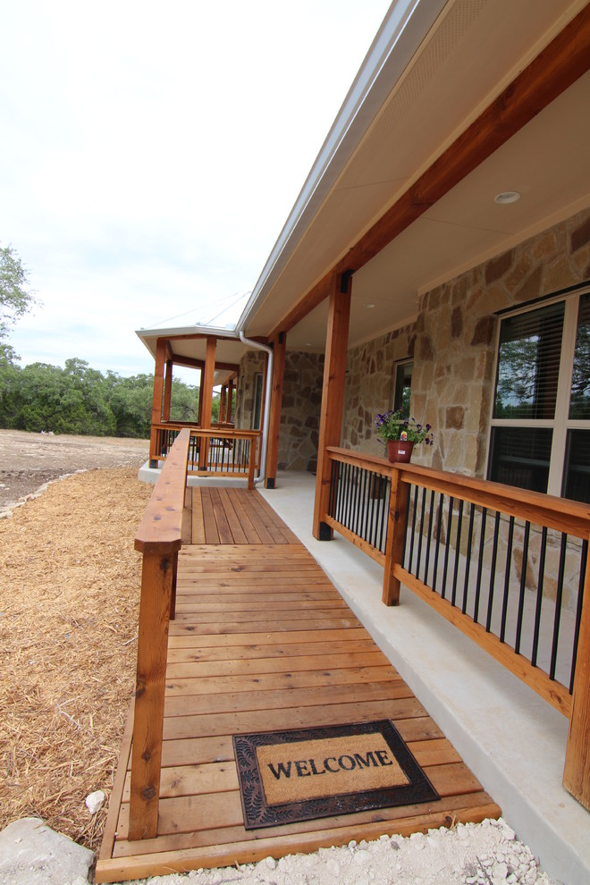 Example of a large country black one-story stone exterior home design in Austin with a gambrel roof