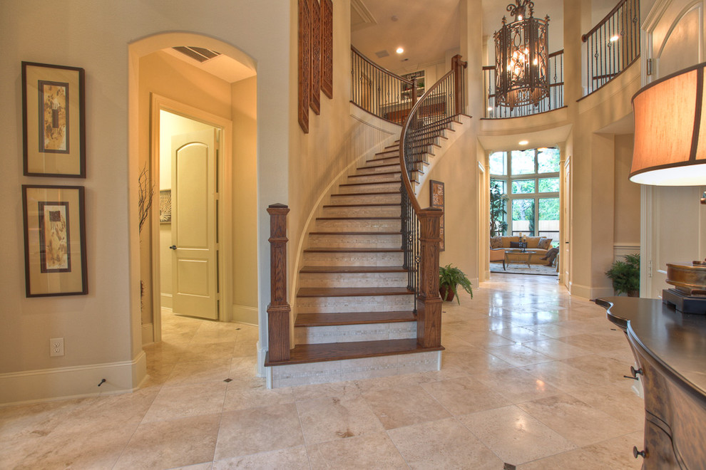 Traditional wood staircase in Houston with travertine risers and mixed railing.