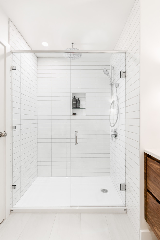 Design ideas for a small midcentury 3/4 bathroom in Vancouver with flat-panel cabinets, medium wood cabinets, an alcove shower, a two-piece toilet, white tile, ceramic tile, white walls, porcelain floors, an undermount sink, engineered quartz benchtops, white floor, a hinged shower door and white benchtops.