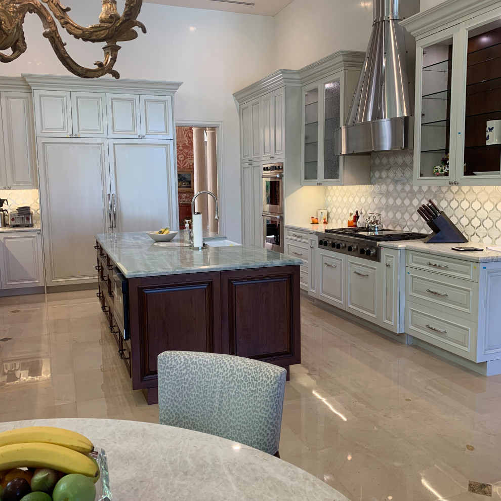 Large transitional u-shaped kitchen in Miami with a farmhouse sink, raised-panel cabinets, white cabinets, quartzite benchtops, white splashback, mosaic tile splashback, panelled appliances, marble floors, with island, beige floor, green benchtop and coffered.