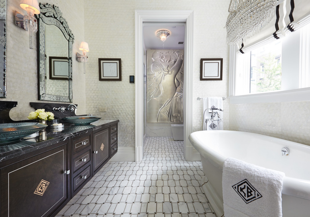This is an example of a traditional bathroom in New York with black cabinets and a freestanding tub.