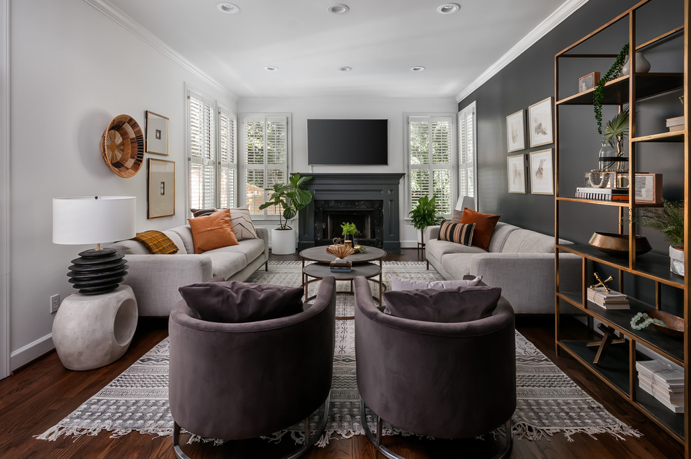 Mid-sized transitional open concept living room in Atlanta with black walls, dark hardwood floors, a standard fireplace, a stone fireplace surround, a wall-mounted tv and brown floor.