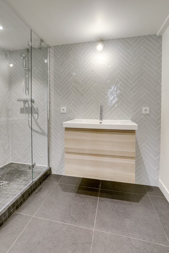 Mid-sized kids bathroom in Paris with an alcove shower, gray tile, matchstick tile, grey walls, cement tiles, a drop-in sink, grey floor, a sliding shower screen, white benchtops and a single vanity.
