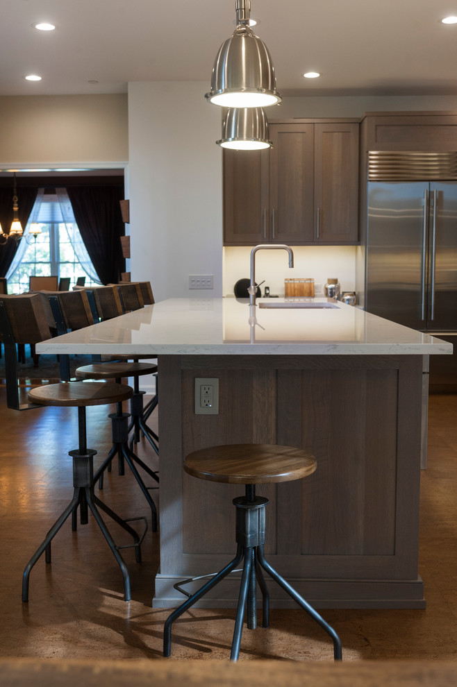 This is an example of a large kitchen in Philadelphia with quartz benchtops, stainless steel appliances, cork floors, with island, an undermount sink, grey cabinets, brick splashback and brown floor.