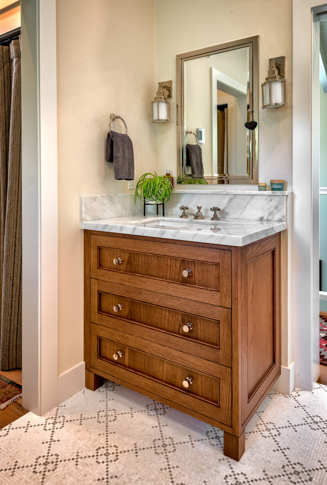 Mid-sized beach style master bathroom in San Francisco with shaker cabinets, medium wood cabinets, an alcove shower, a bidet, white tile, ceramic tile, beige walls, mosaic tile floors, an undermount sink, marble benchtops, white floor, a hinged shower door and white benchtops.