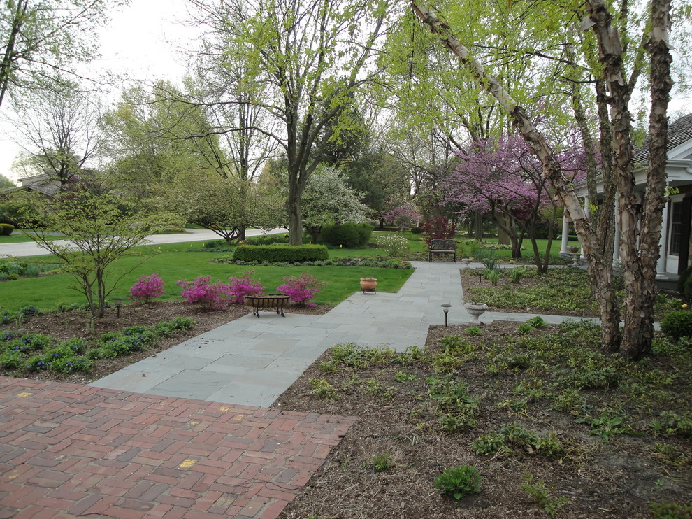 Photo of a large transitional front yard garden in Chicago with a garden path and concrete pavers.