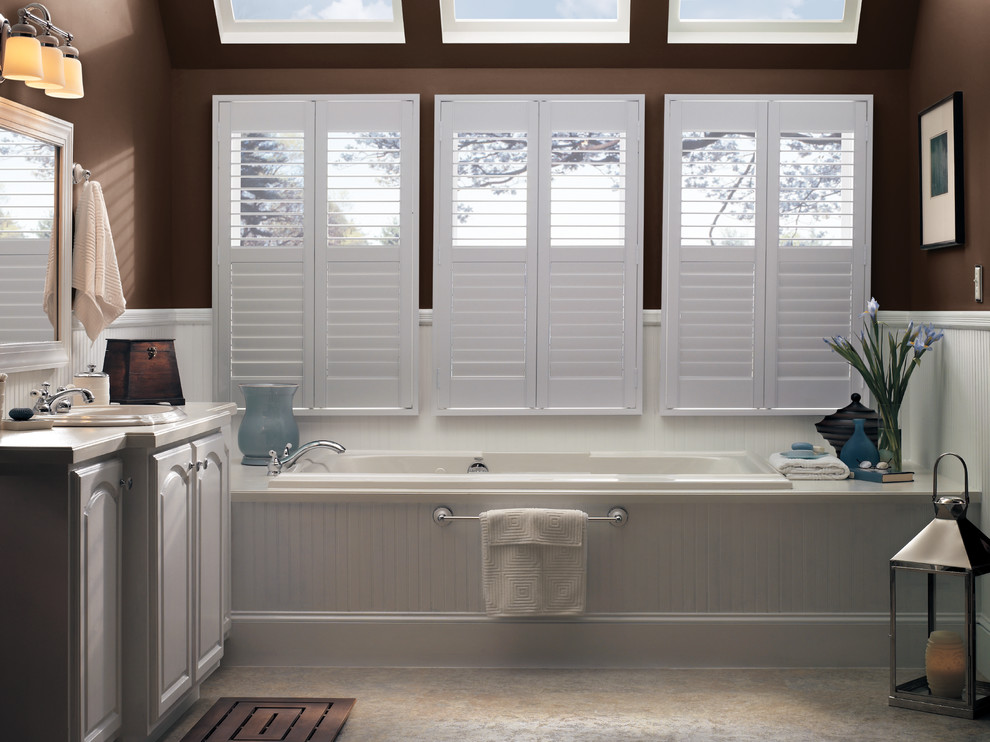 Example of a large transitional master ceramic tile alcove bathtub design with raised-panel cabinets, white cabinets, brown walls and an undermount sink