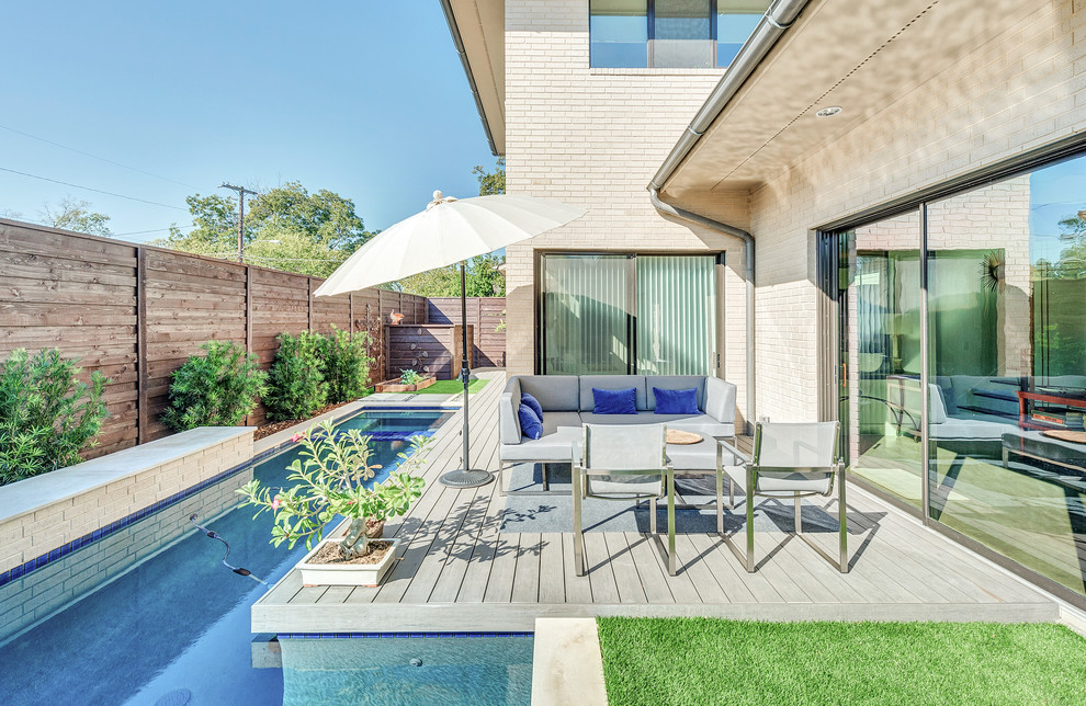 Photo of a contemporary backyard rectangular lap pool in Dallas with a water feature.