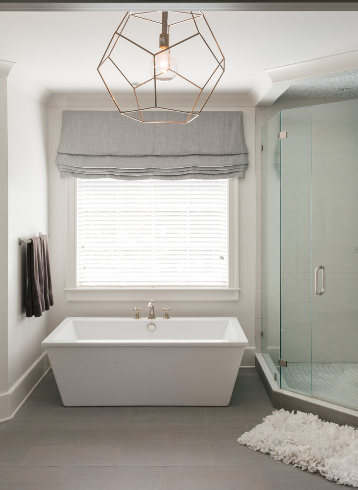 Inspiration for a large transitional master bathroom in Atlanta with a freestanding tub, a hinged shower door, flat-panel cabinets, distressed cabinets, white walls, laminate floors, a vessel sink, solid surface benchtops, brown floor, beige tile and porcelain tile.