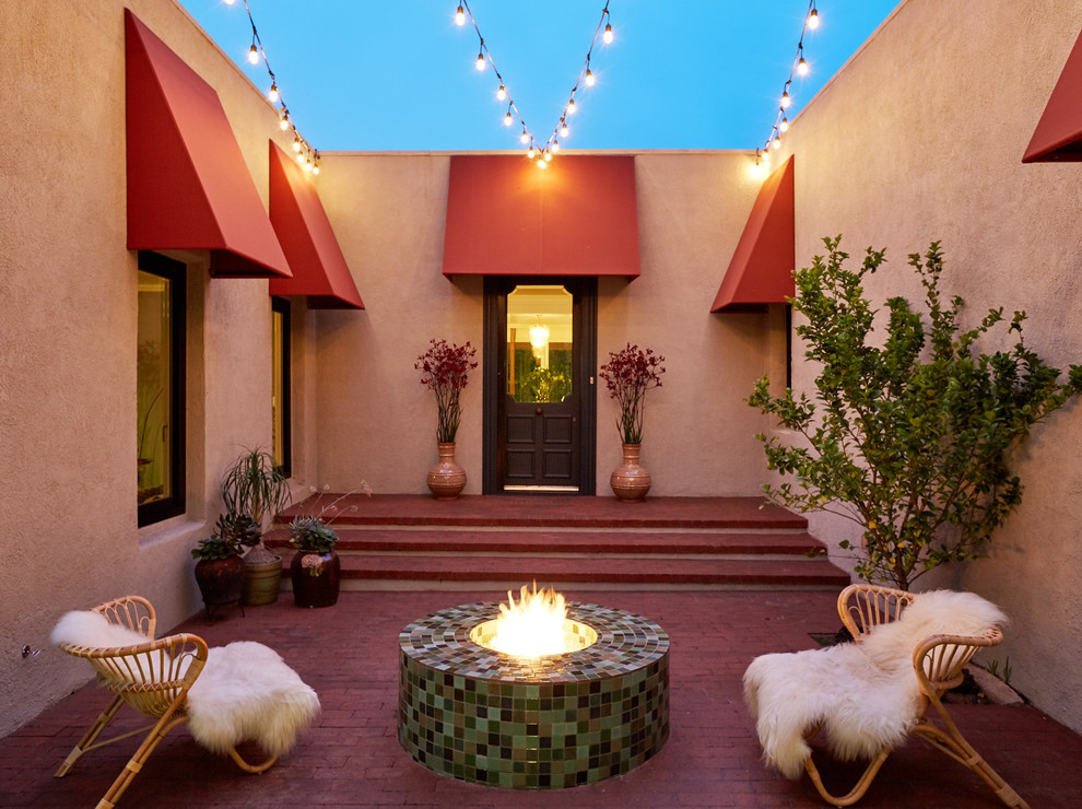 Design ideas for a small eclectic front yard patio in Los Angeles with a fire feature, brick pavers and no cover.