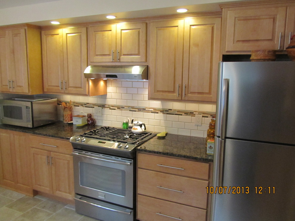 Inspiration for a transitional u-shaped eat-in kitchen remodel in Cleveland with raised-panel cabinets, light wood cabinets, granite countertops, white backsplash, porcelain backsplash and stainless steel appliances