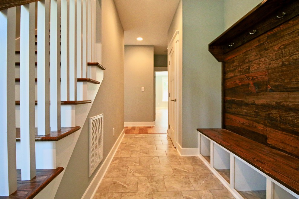 This is an example of a mid-sized traditional mudroom in Raleigh with beige walls, travertine floors and beige floor.