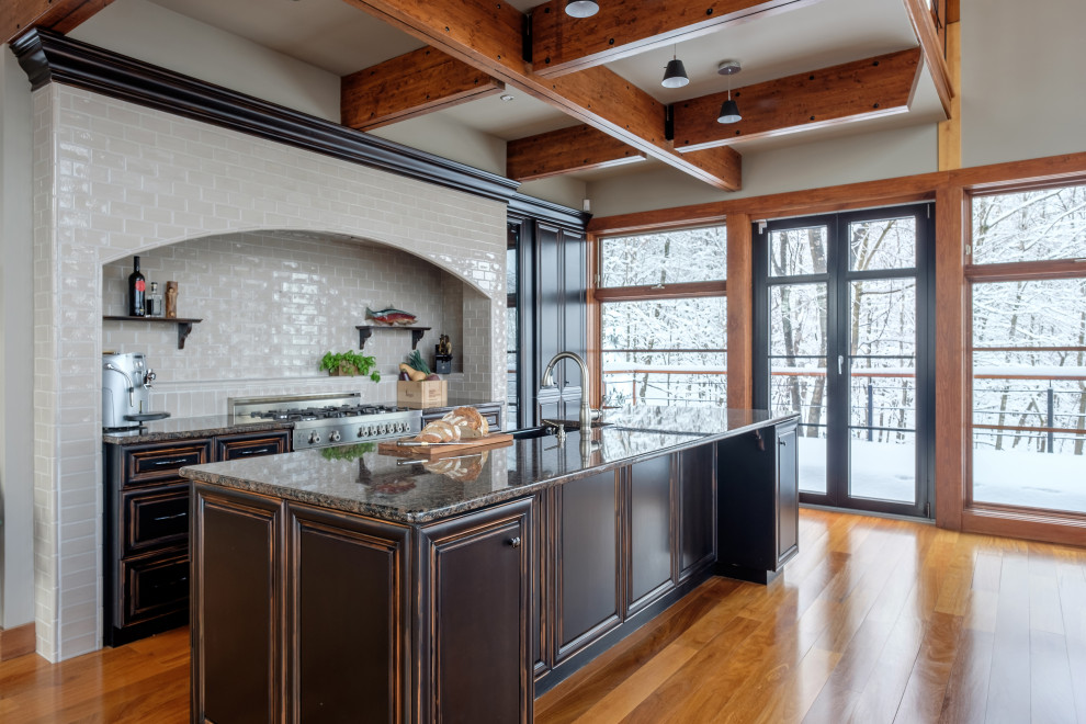 Example of a mountain style single-wall kitchen design in Montreal with a farmhouse sink, stainless steel appliances and an island