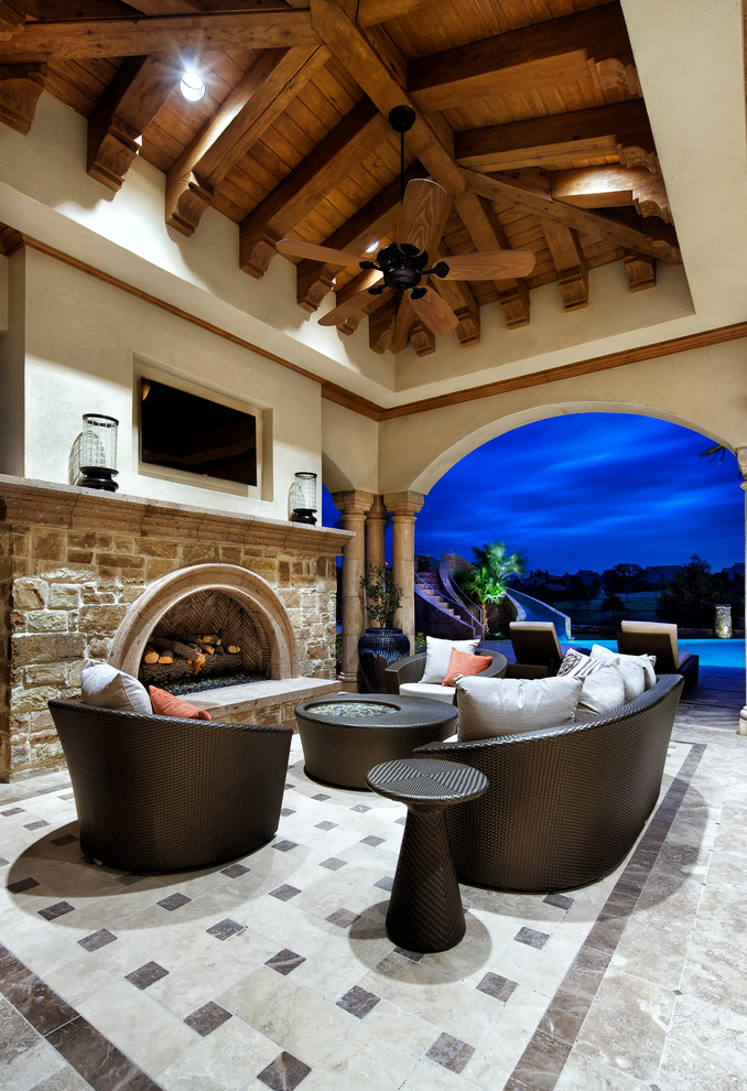 Inspiration for a large mediterranean backyard patio in Houston with a fire feature and a roof extension.