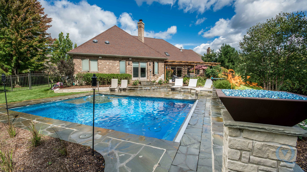 Inspiration for a mid-sized rustic backyard stone and rectangular lap pool fountain remodel in Chicago