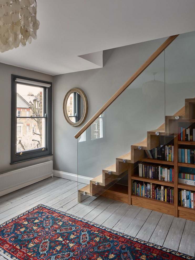 This is an example of a contemporary wood staircase in London with wood risers.