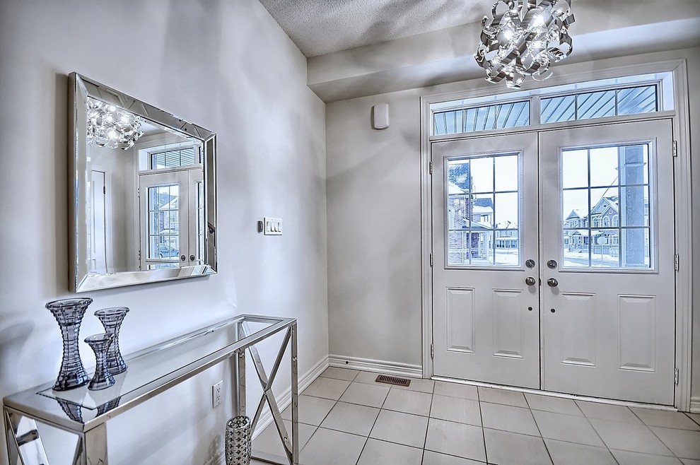 Mid-sized transitional ceramic tile and beige floor foyer photo in Toronto with beige walls and a white front door