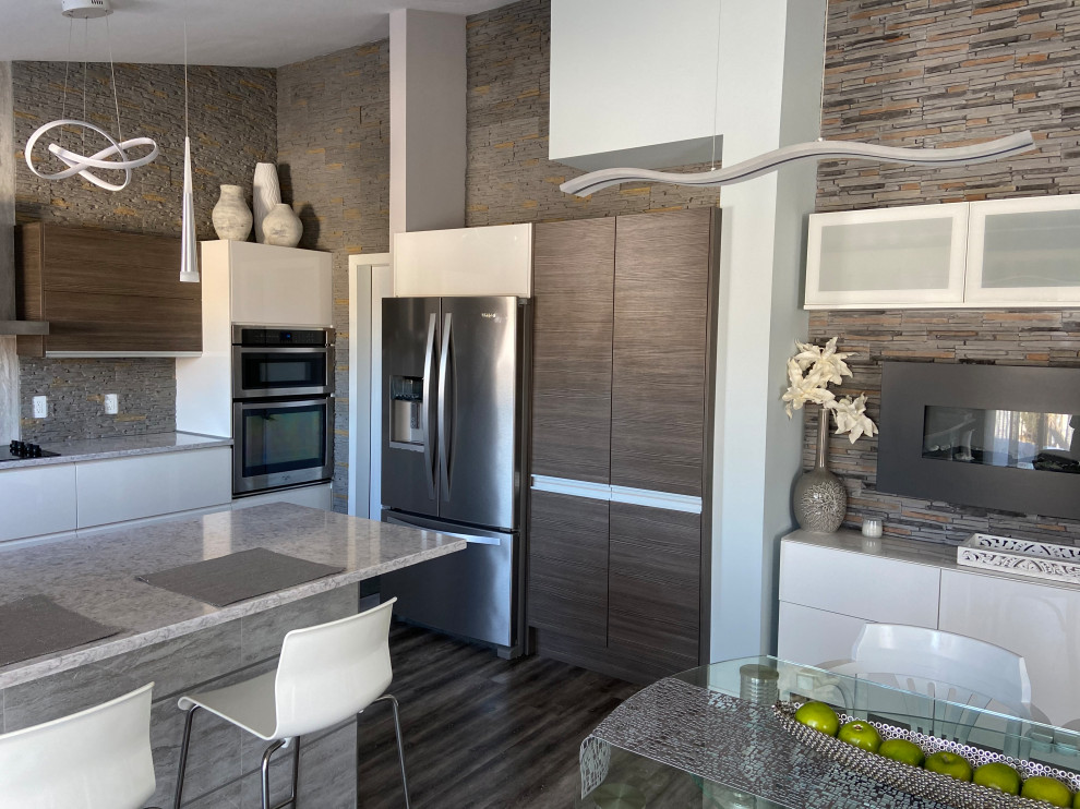 Design ideas for a mid-sized modern u-shaped eat-in kitchen in Other with a drop-in sink, flat-panel cabinets, white cabinets, quartzite benchtops, grey splashback, stone tile splashback, stainless steel appliances, laminate floors, multiple islands, grey floor and white benchtop.