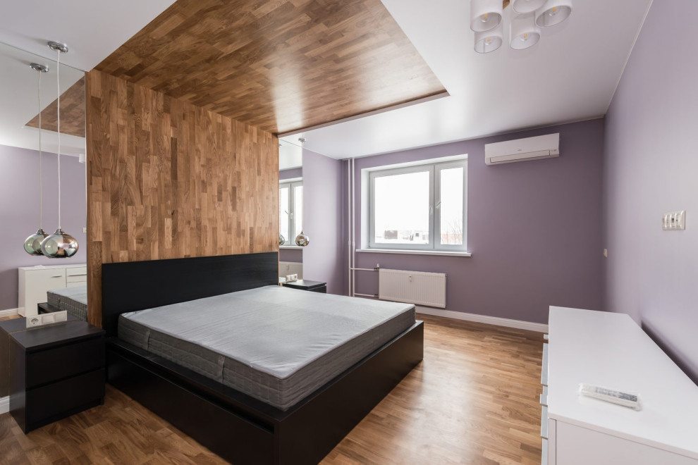 Inspiration pour une chambre parentale design de taille moyenne avec un mur violet, sol en stratifié et un sol beige.