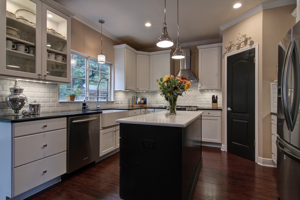 Transitional u-shaped eat-in kitchen photo in Austin with a farmhouse sink, recessed-panel cabinets, white cabinets, quartz countertops, white backsplash, subway tile backsplash and stainless steel appliances