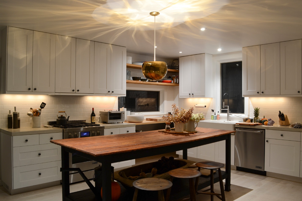 Photo of a large country l-shaped eat-in kitchen in Boston with a double-bowl sink, flat-panel cabinets, white cabinets, granite benchtops, white splashback, ceramic splashback, stainless steel appliances, laminate floors and no island.