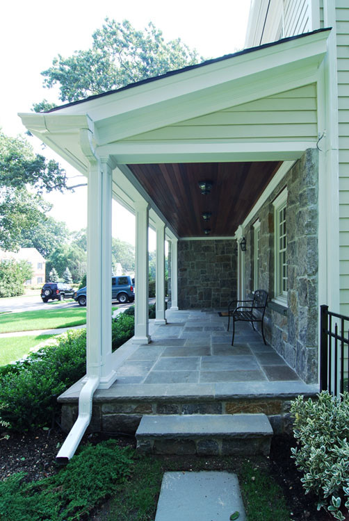 Inspiration for a traditional front yard patio in New York with a roof extension.