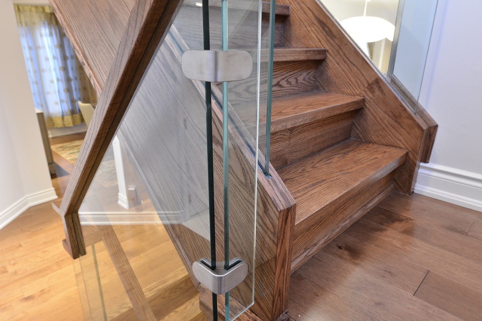 Design ideas for a mid-sized modern wood l-shaped staircase in Toronto with wood risers and glass railing.