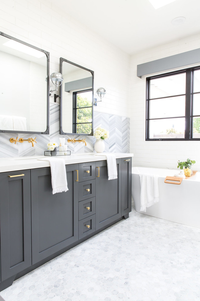 Large country master gray tile and ceramic tile white floor drop-in bathtub photo in Los Angeles with recessed-panel cabinets, gray cabinets and white walls