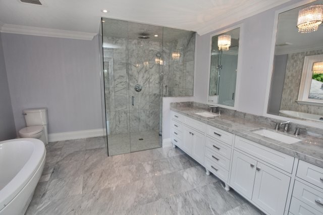 Inspiration for a mid-sized transitional master bathroom in Toronto with shaker cabinets, white cabinets, a freestanding tub, a corner shower, a one-piece toilet, gray tile, white tile, porcelain tile, purple walls, porcelain floors, an undermount sink and marble benchtops.