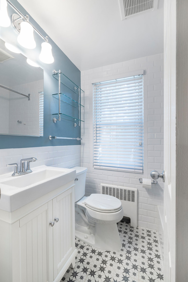 Bathroom - small cottage master white tile and ceramic tile multicolored floor, single-sink, porcelain tile and wainscoting bathroom idea in DC Metro with white cabinets, a one-piece toilet, blue walls, solid surface countertops, white countertops, a niche, a freestanding vanity, beaded inset cabinets and a drop-in sink