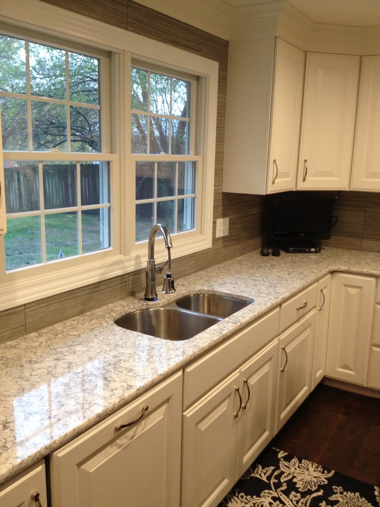 Example of a mid-sized transitional single-wall dark wood floor eat-in kitchen design in Chicago with raised-panel cabinets, white cabinets, granite countertops, gray backsplash, ceramic backsplash, stainless steel appliances and an island