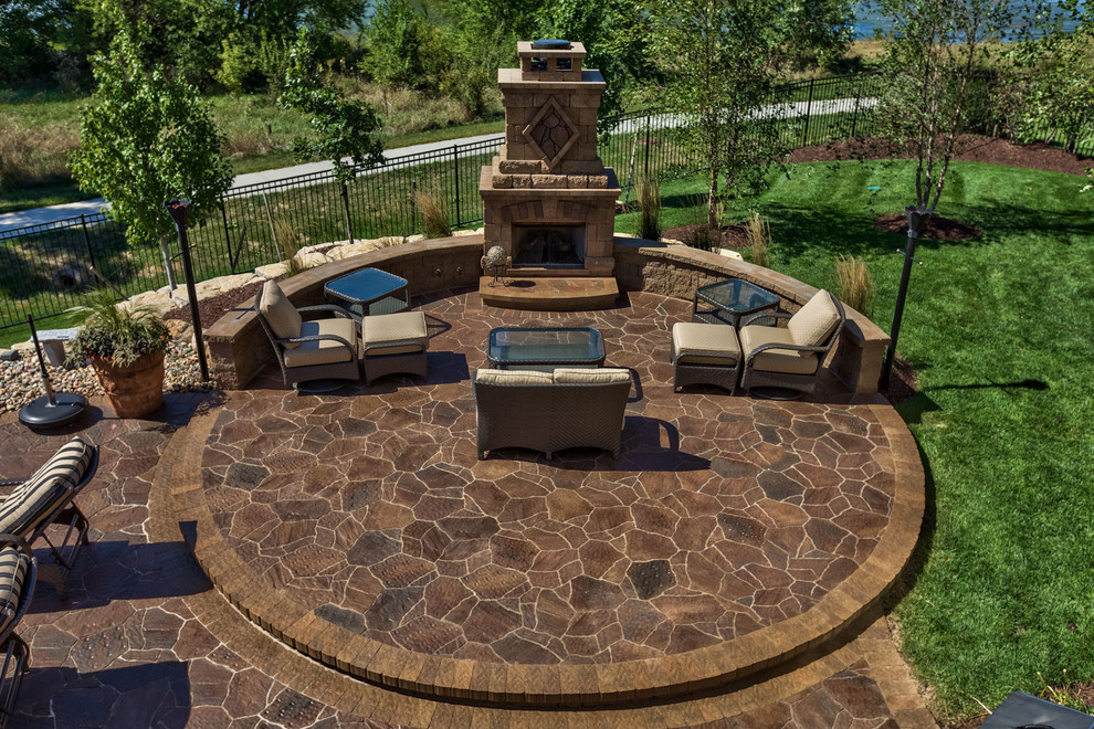 This is an example of a mid-sized beach style backyard patio in Omaha with a fire feature, concrete pavers and no cover.