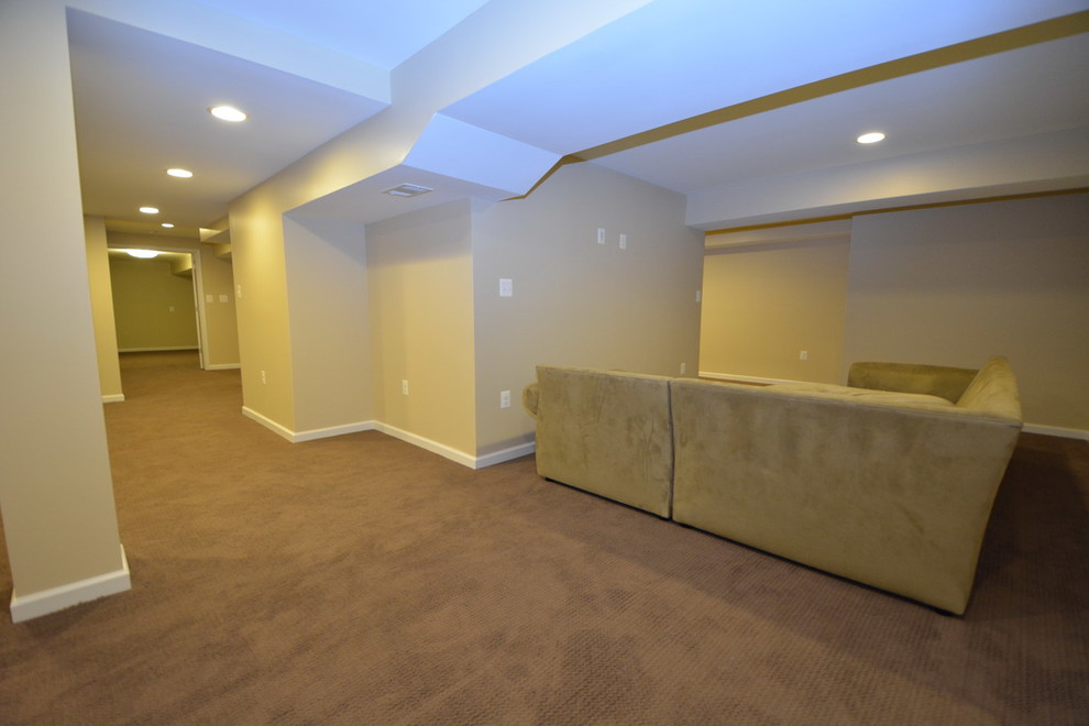 Large traditional walk-out basement in Baltimore with yellow walls, carpet, no fireplace and brown floor.