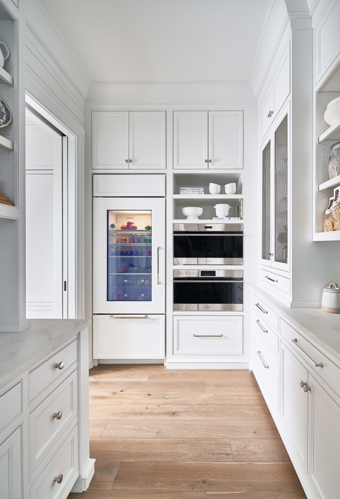 Cette image montre une arrière-cuisine marine avec un placard à porte affleurante, des portes de placard blanches, plan de travail en marbre et un plan de travail blanc.