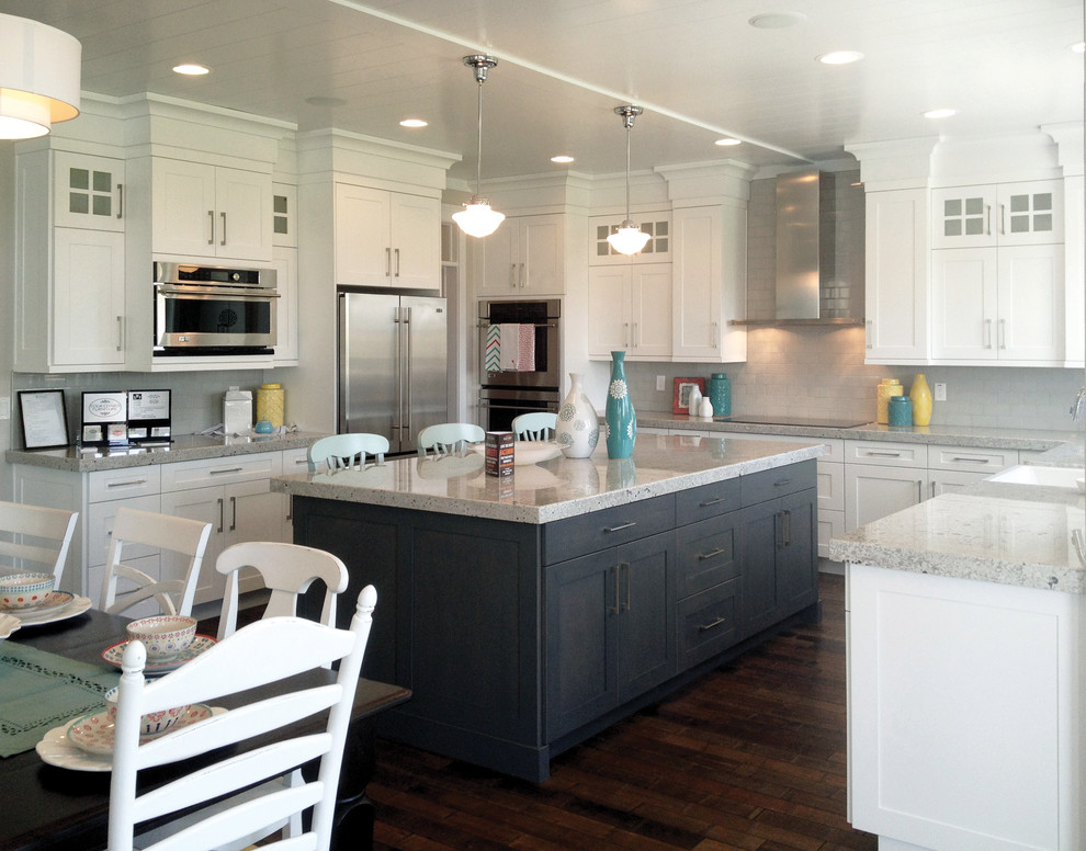 Inspiration for a large transitional eat-in kitchen in Seattle with a farmhouse sink, white cabinets, grey splashback, stainless steel appliances, dark hardwood floors, with island and shaker cabinets.