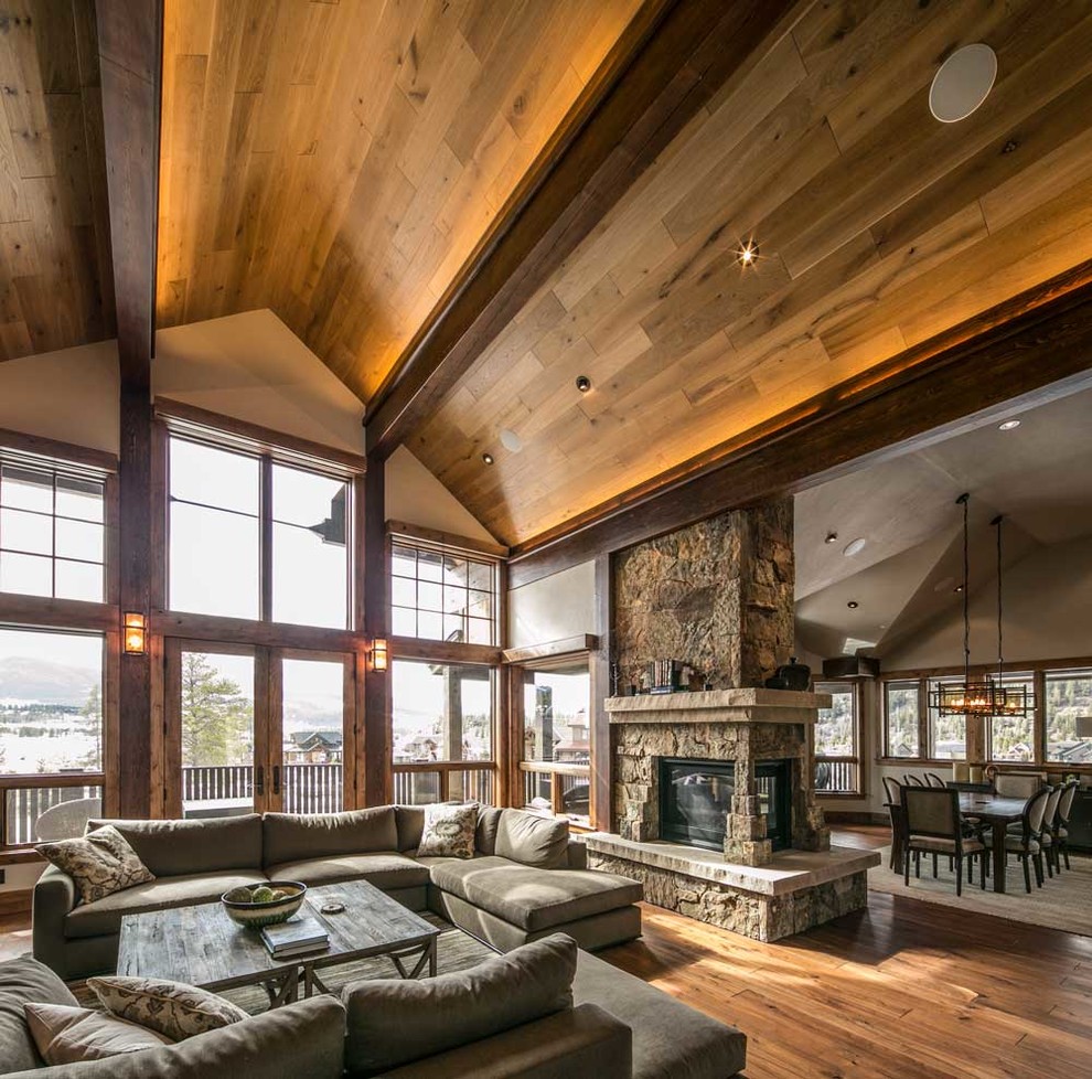 Expansive country open concept family room in Denver with a stone fireplace surround, a built-in media wall, white walls, dark hardwood floors and a corner fireplace.