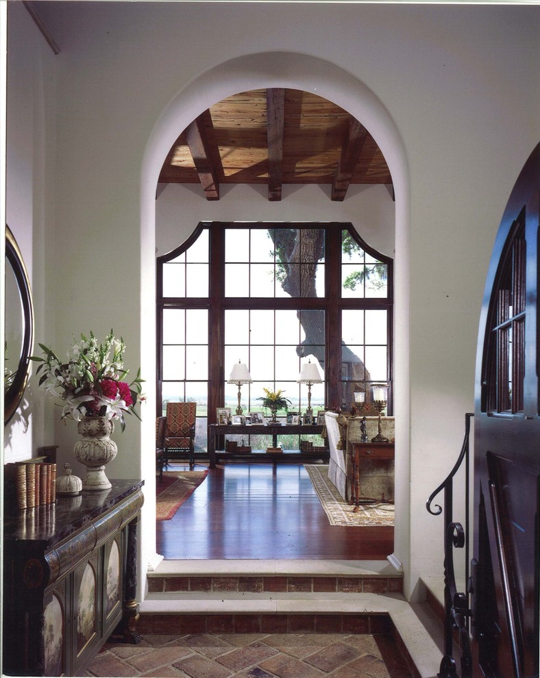 This is an example of a mediterranean vestibule in Atlanta with white walls and brick floors.