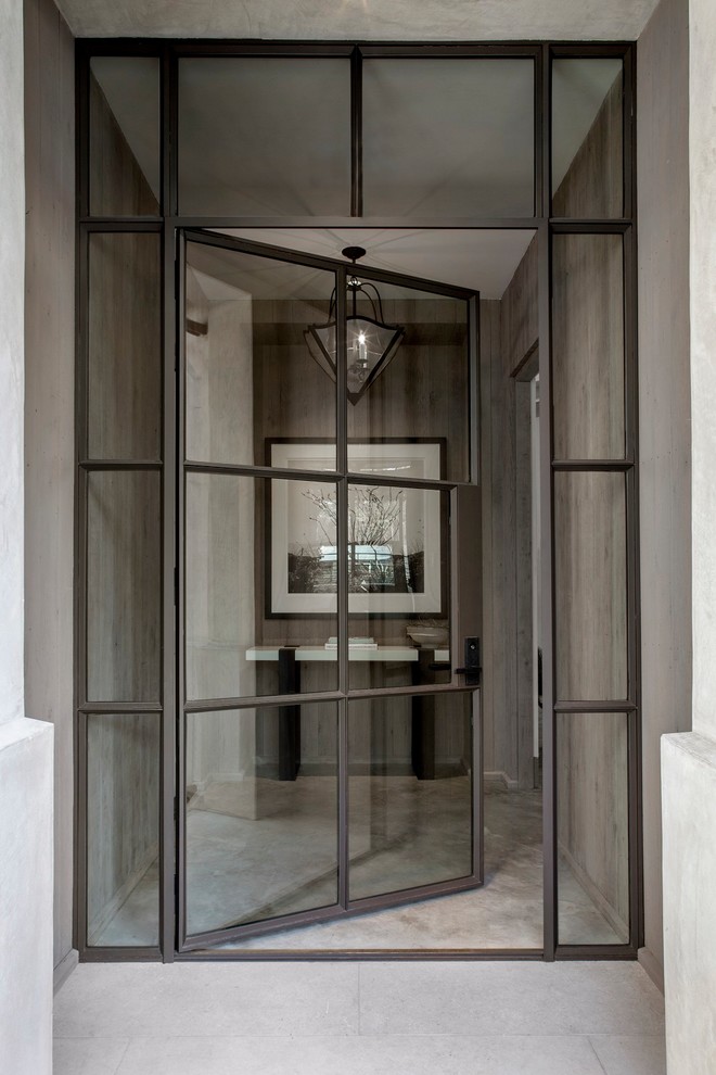 This is an example of a large mediterranean entryway in Austin with beige walls, a single front door and a metal front door.