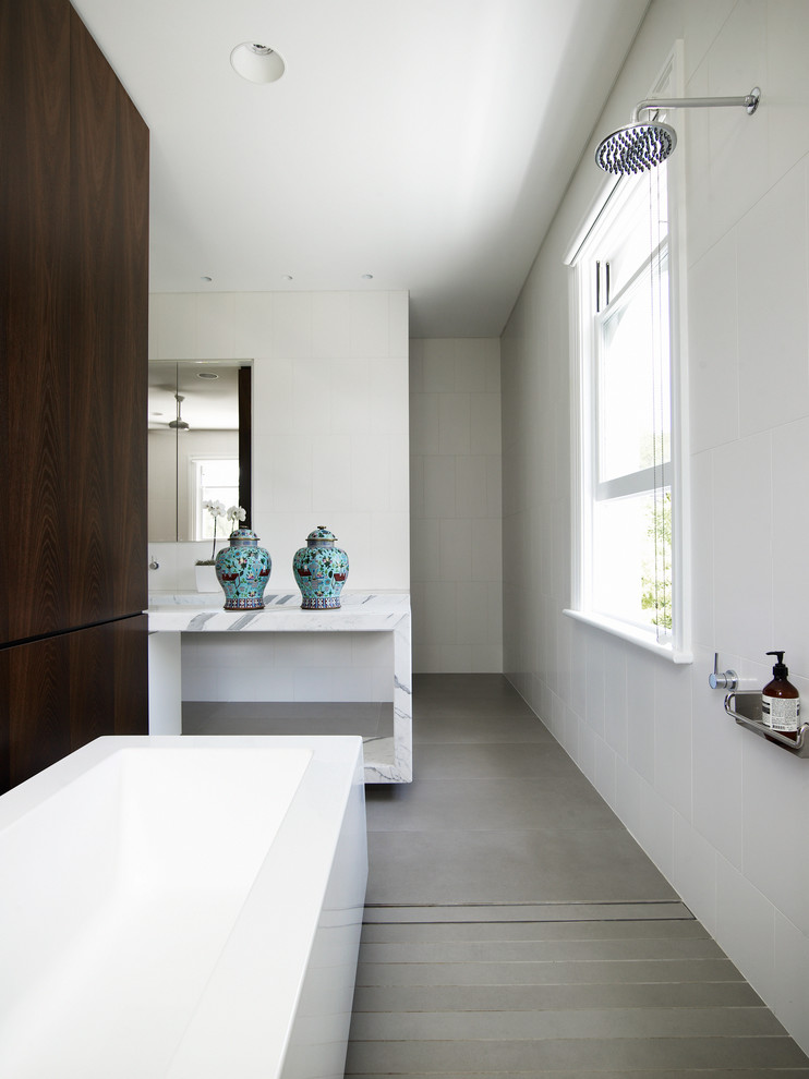 Inspiration for a large modern master bathroom in Sydney with an undermount sink, furniture-like cabinets, dark wood cabinets, marble benchtops, a freestanding tub, a double shower, beige tile, stone tile, white walls and travertine floors.