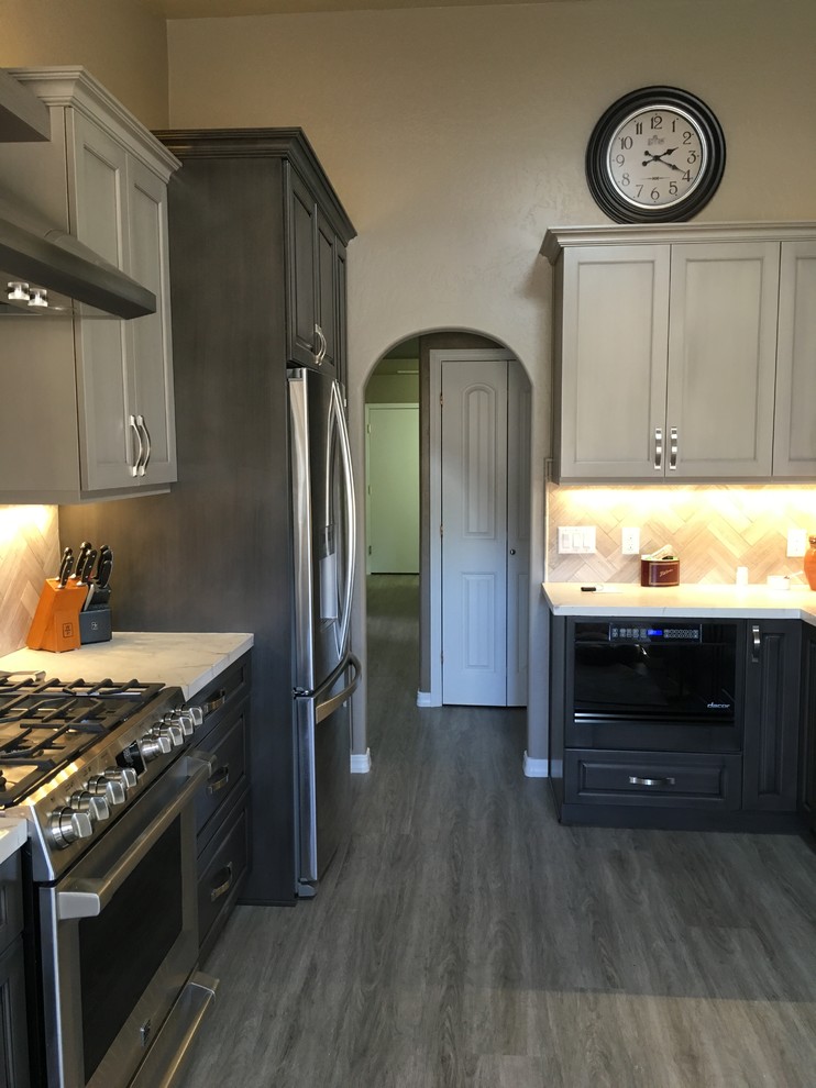 Example of a mid-sized transitional dark wood floor and brown floor eat-in kitchen design in Phoenix with a single-bowl sink, raised-panel cabinets, dark wood cabinets, onyx countertops, brown backsplash, ceramic backsplash, stainless steel appliances and an island