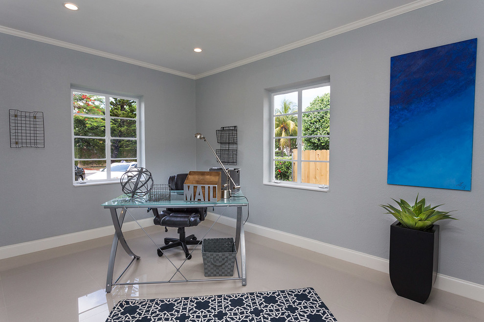 This is an example of a mid-sized contemporary study room in Miami with grey walls, linoleum floors, no fireplace and a freestanding desk.