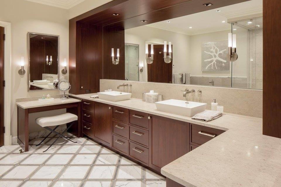 Inspiration for a large contemporary master bathroom in Los Angeles with recessed-panel cabinets, dark wood cabinets, a corner shower, beige walls, marble floors, a vessel sink, white floor, a hinged shower door and beige benchtops.