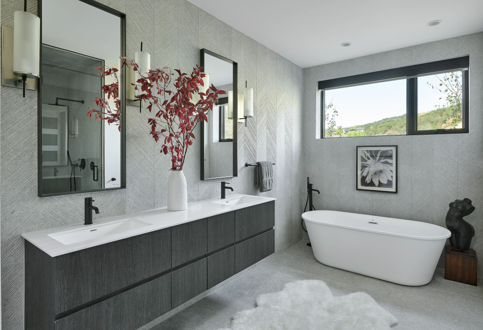 Example of a large trendy master gray tile and porcelain tile porcelain tile and double-sink freestanding bathtub design in Denver with flat-panel cabinets, brown cabinets, white countertops and a floating vanity