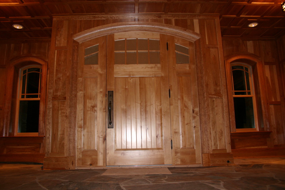 Example of a large arts and crafts limestone floor front door design