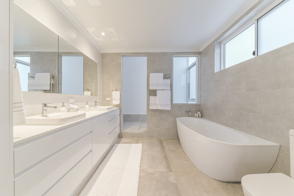 Design ideas for a modern master bathroom in Perth with flat-panel cabinets, white cabinets, beige tile, beige walls, beige floor, white benchtops, a corner tub, an open shower, a one-piece toilet, cement tile, concrete floors, a drop-in sink and an open shower.
