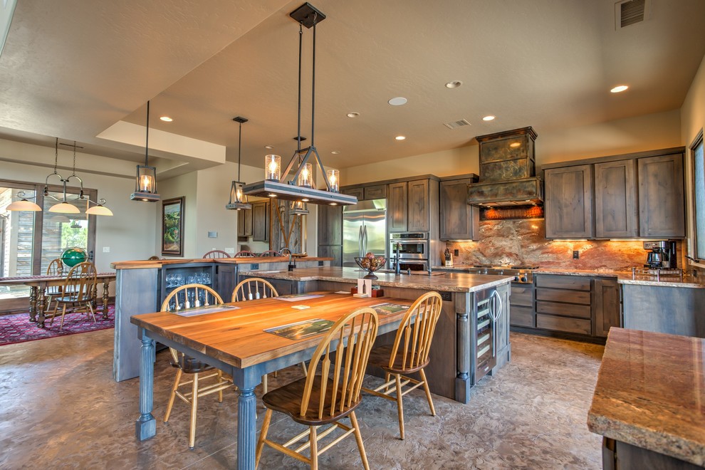 Photo of a large country galley eat-in kitchen in Phoenix with a triple-bowl sink, shaker cabinets, grey cabinets, brown splashback, stone slab splashback, stainless steel appliances, concrete floors and multiple islands.